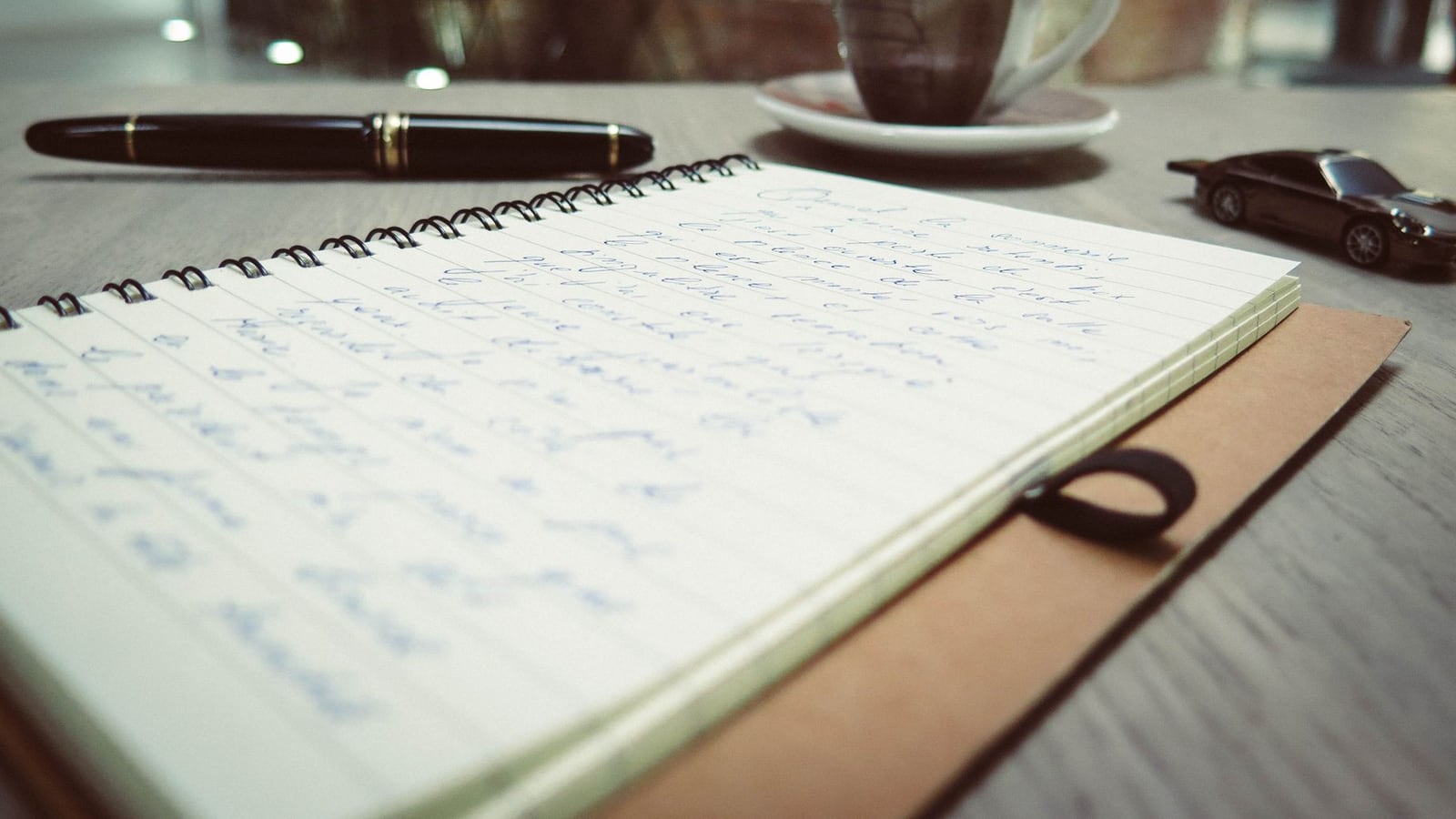 Notizbuch und Stift neben einem Studiomonitor zur Projektplanung in Linz.